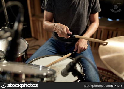 music, people, musical instruments and entertainment concept - male musician playing drums and cymbals at concert or studio. male musician playing drums and cymbals at concert