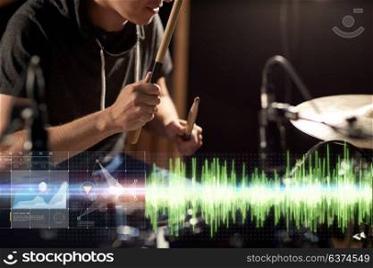 music, people, musical instruments and entertainment concept - male musician with drumsticks playing drum kit at concert or studio. male musician playing drum kit at concert