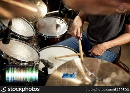 music, people, musical instruments and technology concept - male musician playing drum kit at concert or studio. male musician playing drum kit at concert