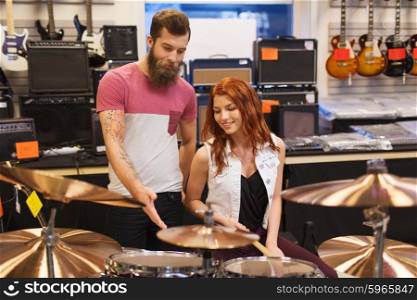 music, sale, people, musical instruments and entertainment concept - happy man and woman with drum kit at music store