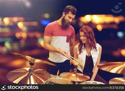 music, sale, people, musical instruments and entertainment concept - happy man and woman with drum kit at music store. man and woman with drum kit at music store