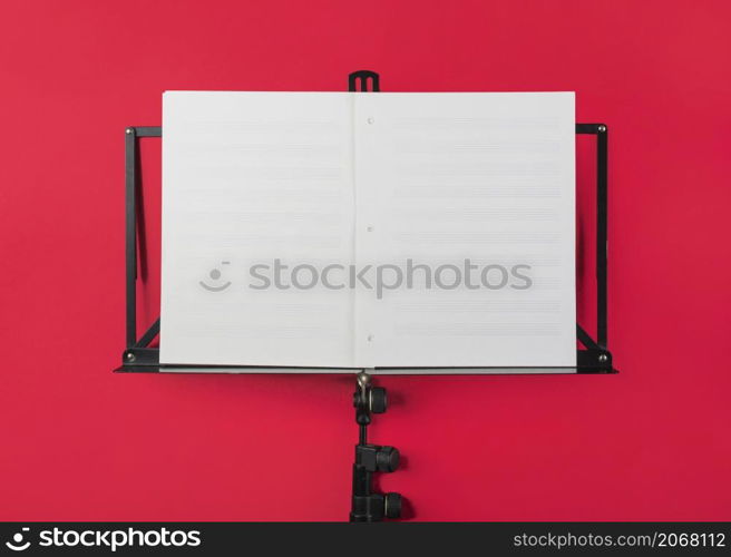 music stand with blank white musical page red backdrop
