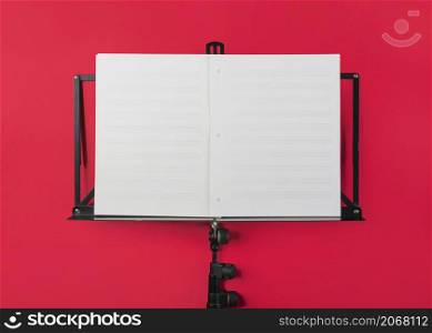 music stand with blank white musical page red backdrop