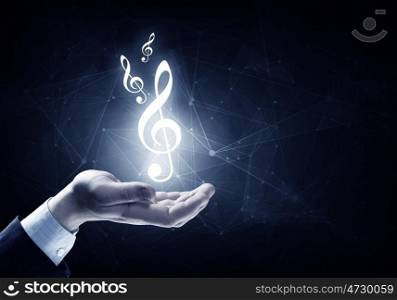 Music symbol in hand. Close up of hand holding music icon in palm