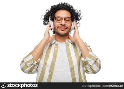 music, technology and people concept - happy smiling young man in headphones over white background. happy smiling young man in headphones
