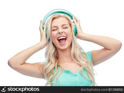 music, technology and people concept - happy young woman or teenage girl with headphones singing song