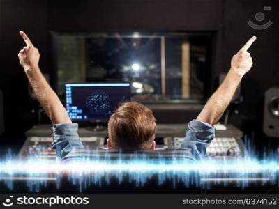 music, technology and people concept - man at mixing console in sound recording studio. man at mixing console in music recording studio