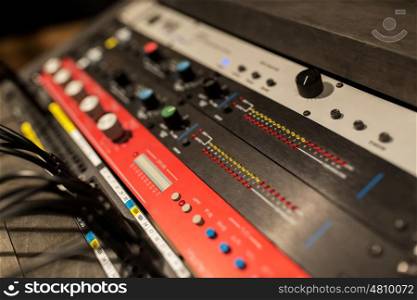 music, technology, electronics and equipment concept - mixing console at sound recording studio