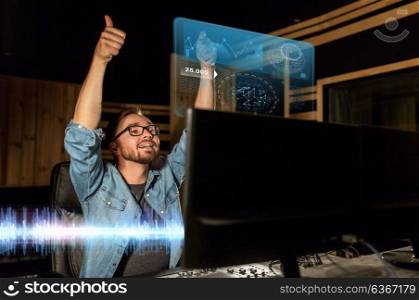 music, technology, gesture and people concept - happy man at mixing console in sound recording studio showing thumbs up. man at mixing console in music recording studio