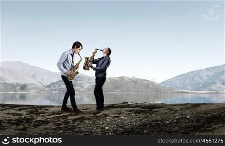 Musical duet. Duet of young man and woman musicians playing saxophones