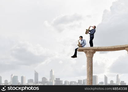 Musical duet. Duet of young man and woman musicians playing saxophones