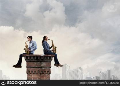 Musical duet. Duet of young man and woman musicians playing saxophones