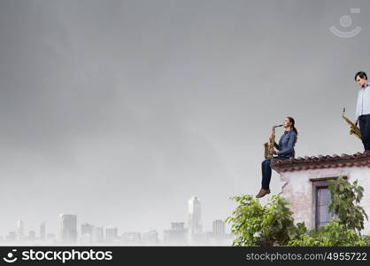 Musical duet. Duet of young man and woman musicians playing saxophones