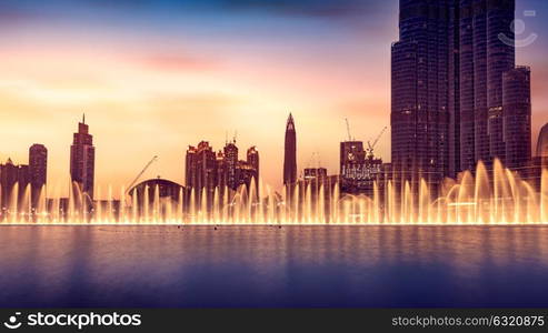 Musical fountain of Dubai, amazing beautiful fountain glowing at night, world famous tourist attraction, traveling to UAE