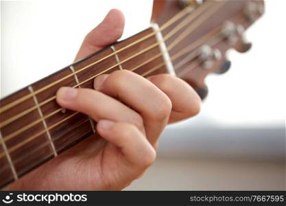 musical instruments concept - close up of hand with guitar neck playing music. close up of hand with guitar neck playing music