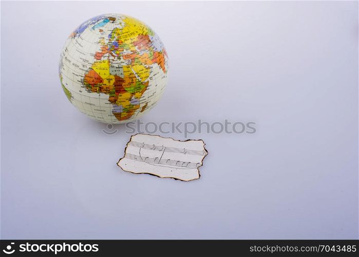 Musical notes on a burnt paper and a little model globe