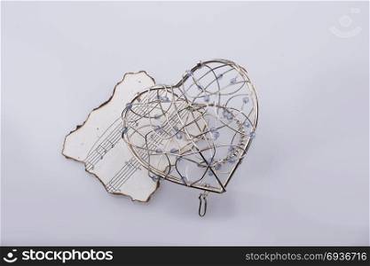 Musical notes on a burnt paper under a heart shape metal icon