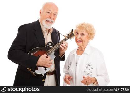 Musical senior couple. He plays mandolin and she sings along. Isolated on white.