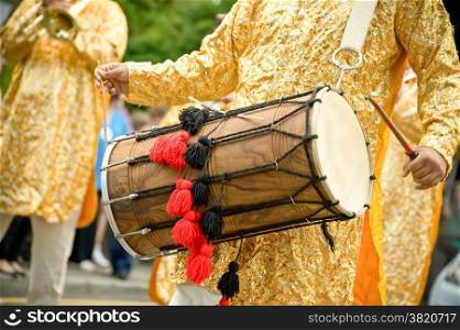 musician playing a traditional asian indian dhol drum
