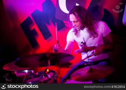 musician playing drums on a red background