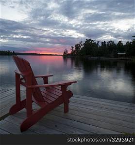 Muskoka chair on the dock at sunset in Lake of the Woods, Ontario