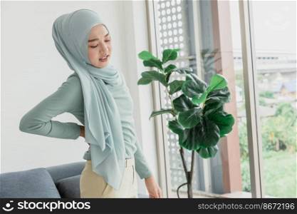 muslim arab women hand at back pain, Waist pain painful expression from office syndrome.