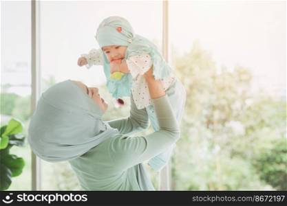 Muslim family or Islam mother with her healthy baby happiness playing together at lovely home. single mom.