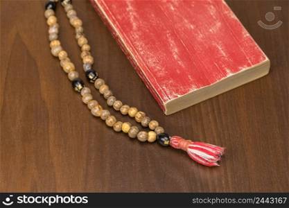 Muslim prayer beads and Quran isolated on a wooden background. Islamic and Muslim concepts. Ramadan, the Muslim rosary