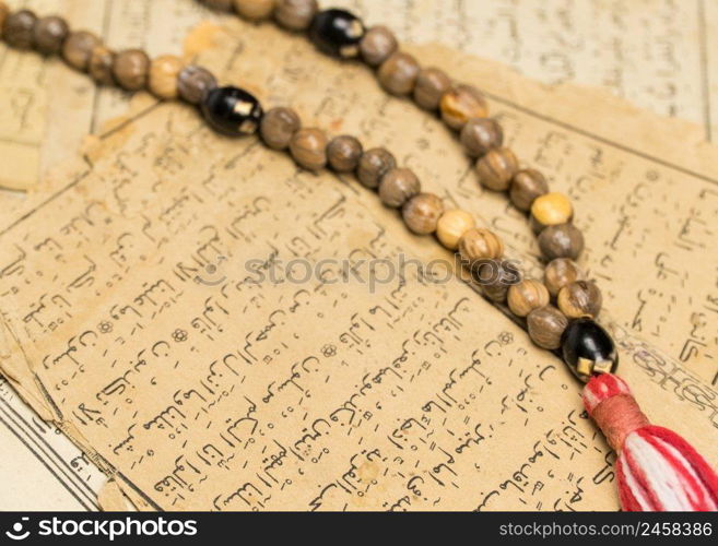 Muslim prayer beads with ancient pa≥s from the Koran. Islamic and Muslim concepts. Ancient old sheets of paper from the Arabic book. Ramadan, the Muslim rosary
