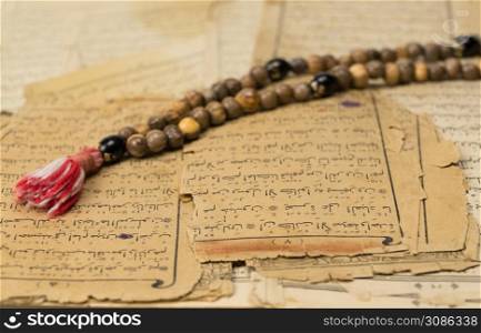Muslim prayer beads with ancient pages from the Koran. Islamic and Muslim concepts. Ancient old sheets of paper from the Arabic book. Ramadan, the Muslim rosary