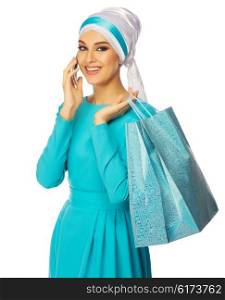 Muslim woman in blue dress with bags and phone isolated