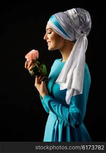 Muslim woman in blue dress with rose on black