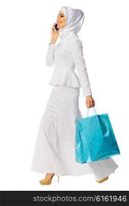 Muslim woman in white dress with phone and bags isolated