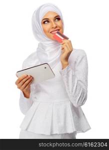 Muslim woman in white dress with tablet PC and plastic card isolated