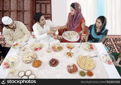 Muslim woman serving food during Id