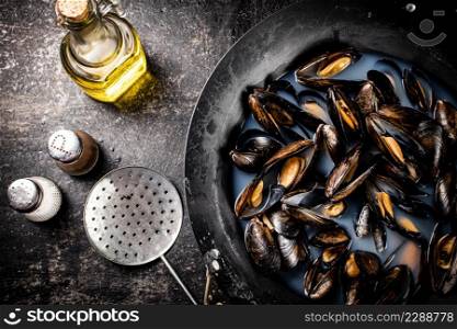 Mussels are cooked in a pot of water. On a black background. High quality photo. Mussels are cooked in a pot of water.