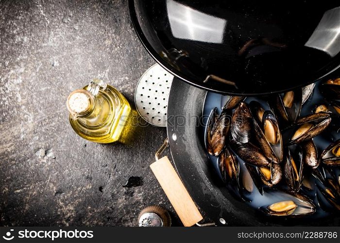 Mussels are cooked in a pot of water. On a black background. High quality photo. Mussels are cooked in a pot of water.