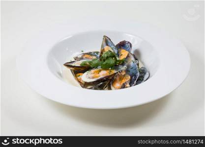Mussels in a Creamy Sauce in a white bowl on a white background isolated