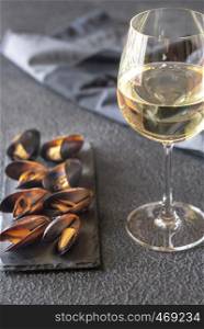 Mussels with a glass of white wine on the dark background