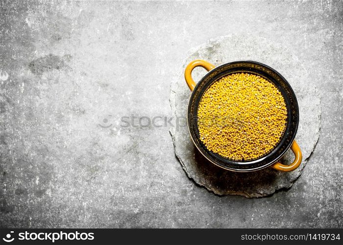 Mustard seeds in a bowl. On the stone table.. Mustard seeds in a bowl.