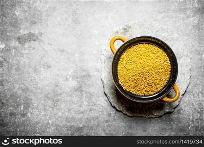 Mustard seeds in a bowl. On the stone table.. Mustard seeds in a bowl.