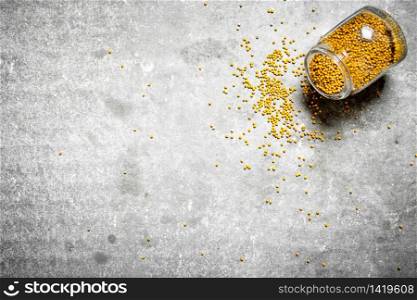 Mustard seeds in glass jar. On the stone table.. Mustard seeds in glass jar.
