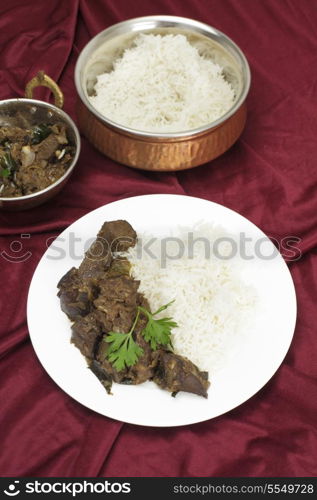 Mutton liver fried with onion and indian spices to make a traditional Kerala (South India) fry, served with basmati long-grain rice