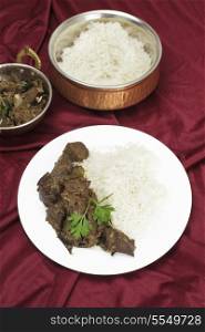Mutton liver fried with onion and indian spices to make a traditional Kerala (South India) fry, served with basmati long-grain rice