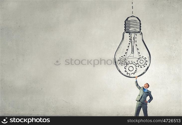 My big idea. Young businessman holding in hands big light bulb