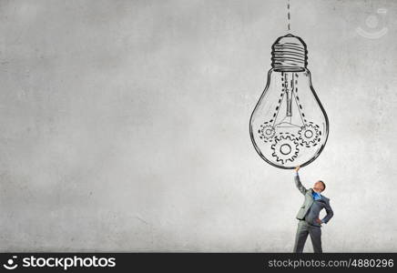 My big idea. Young businessman holding in hands big light bulb