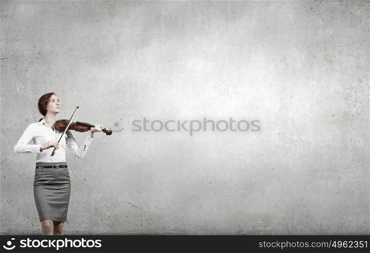 My business melody. Young businesswoman on cement background playing violin