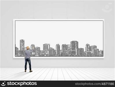 My development project. Rear view of builder man drawing construction project on white banner