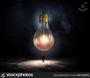 My great idea. Back view of businessman looking at big light bulb