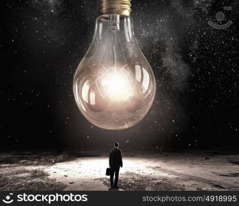 My great idea. Back view of businessman looking at big light bulb